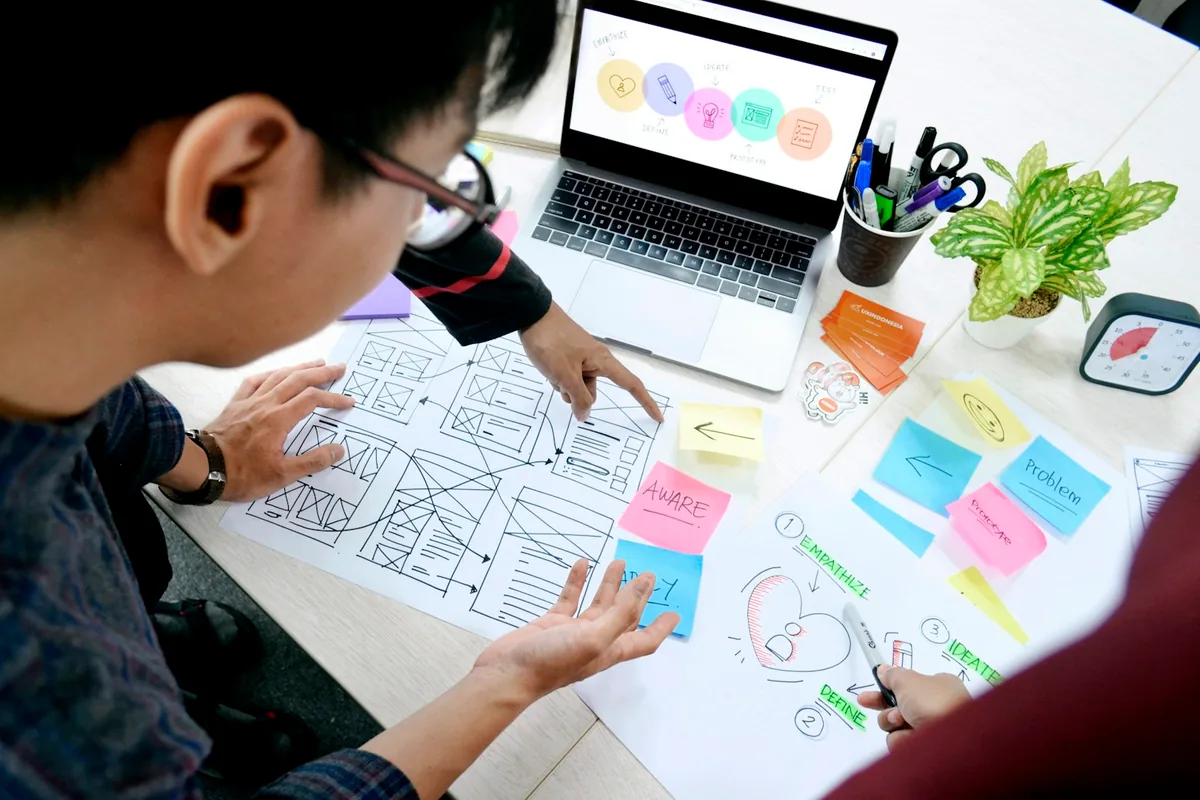 Designer planning interface wireframes at a desk